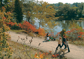 Family walking on trail near grand river
