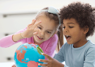 Two kids look at a globe
