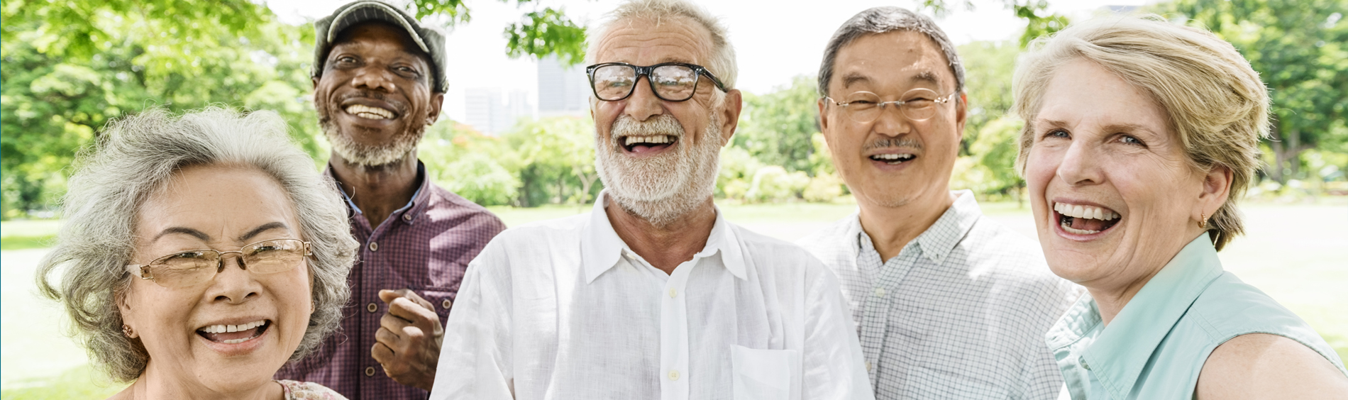 A group of multicultural seniors stand together smiling