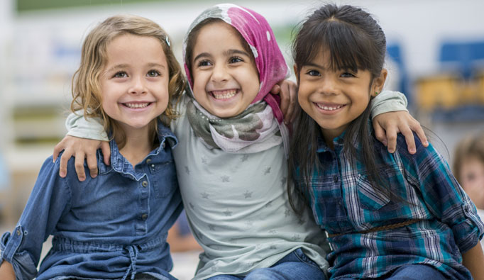 3 young girls sitting and hugging