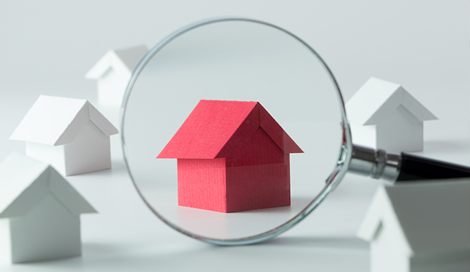 A magnifying glass aimed at a red house