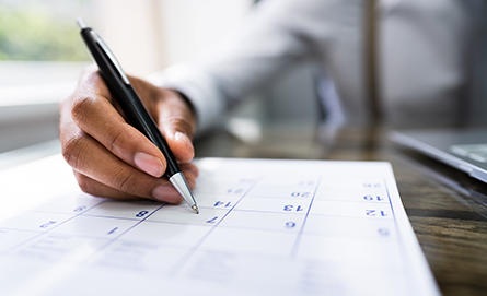 Person making a note on a paper calendar