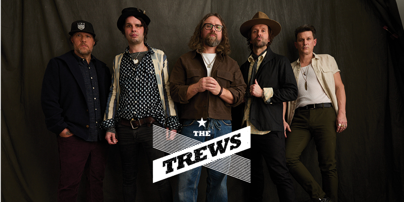 Image of The Trews band members lined up side by side with a brown background and their logo