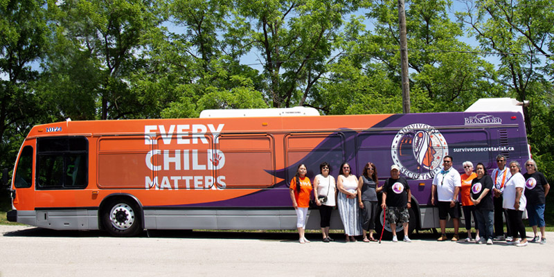 Survivors in front of the Indigenous Peoples Bus Wrap