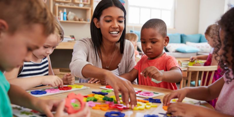 Group of children and Early Childhood Educator working on a craft together