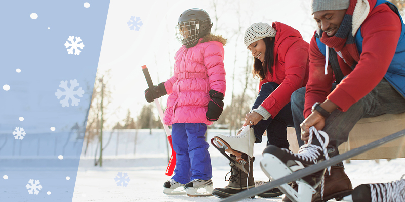 Family lacing up ice skates by the outdoor rink