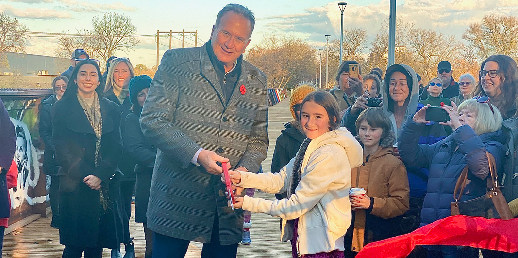 Mayor Kevin Davis and a young volunteer participating in the ribbon cutting ceremony