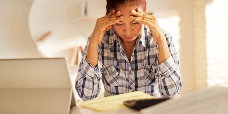 A woman doing her taxes looking frustrated