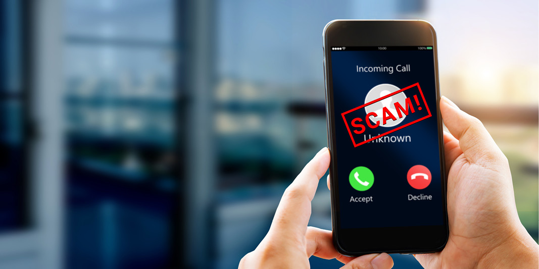 Cell phone with an incoming call from an unknown number and the word scam across the screen