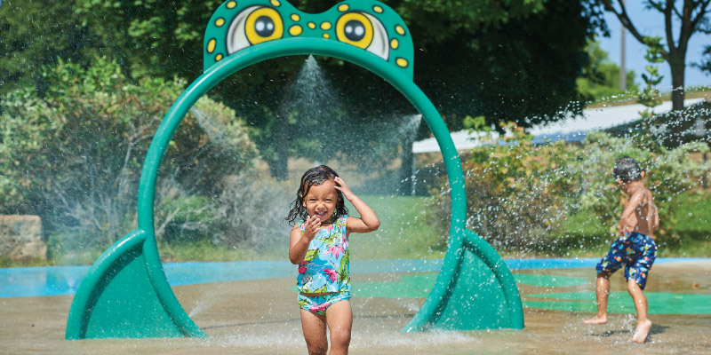 Girl playing in sprinkler