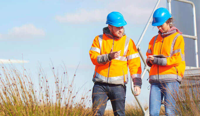 two field workers taking measurements