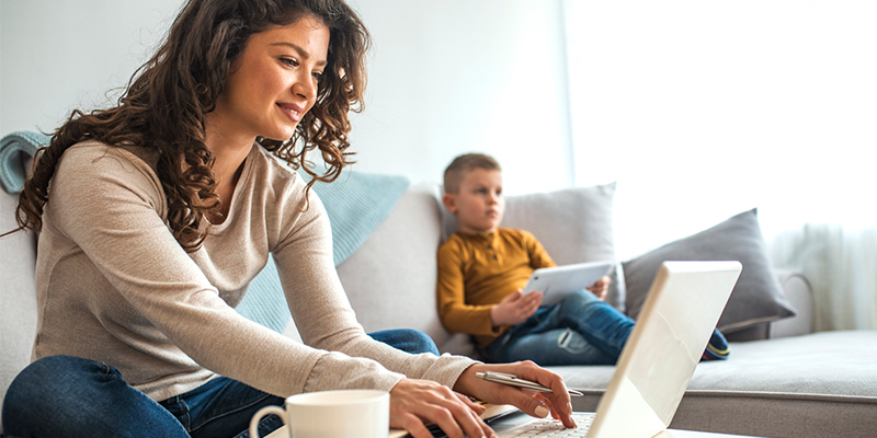 single mother working on computer with son