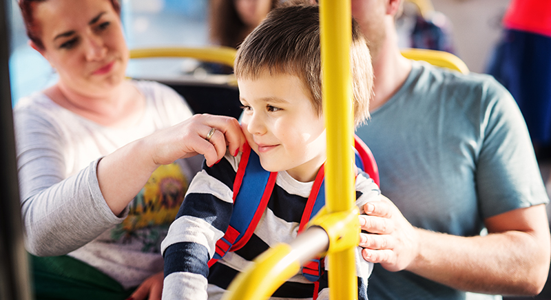 Boy riding a bus with his parents