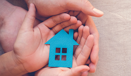 Hands holding a blue home