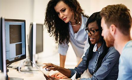 Individuals looking at a computer