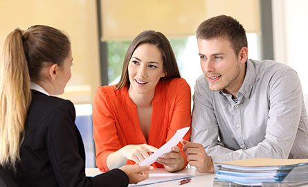 Picture of individuals gathered around a computer