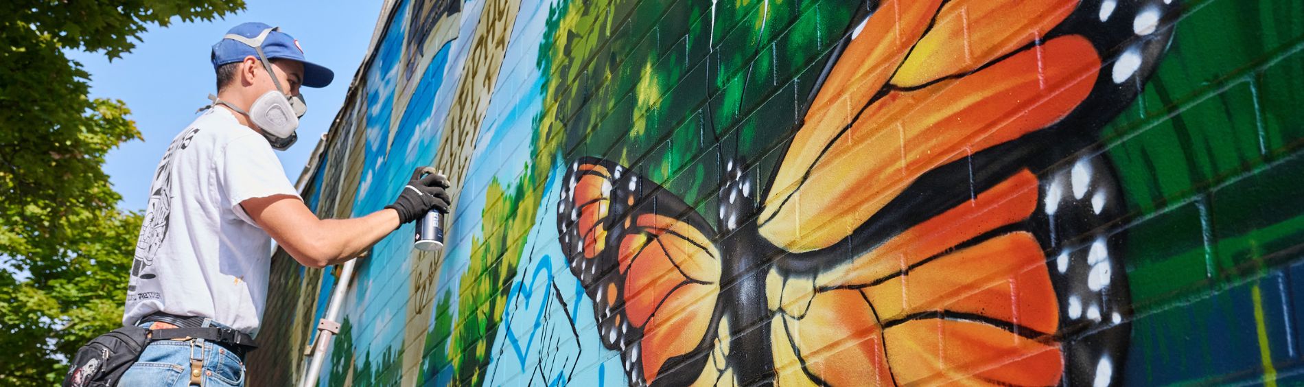 An artist painting a mural on a wall