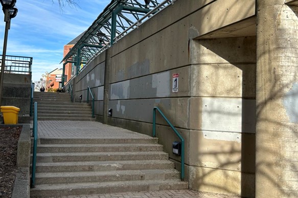 Mural Location, to the right of the stairs ascending from the Market St. Parkade to Colborne St. E.