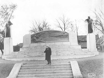 Alexander Graham Bell standing before the newly-unveiled Bell Memorial, 1917