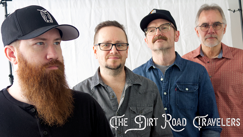 Four members of the band "The Dirt Road Travelers" pose in front of a white backdrop