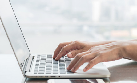 Hands on a laptop keyboard computer