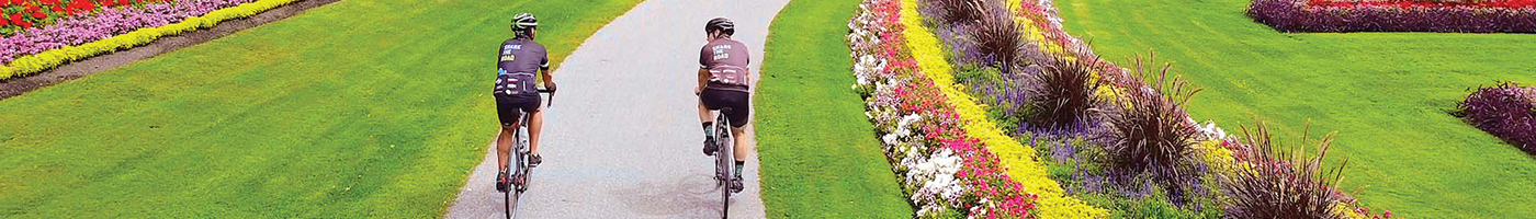Cyclists on a paved trail in a beautiful garden