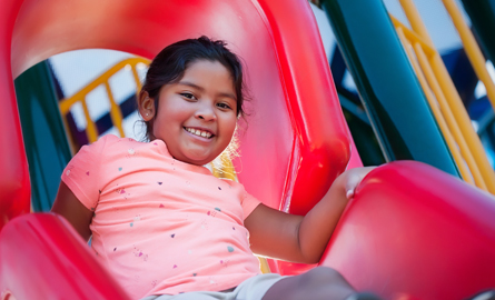 Girl sliding down a playground slide