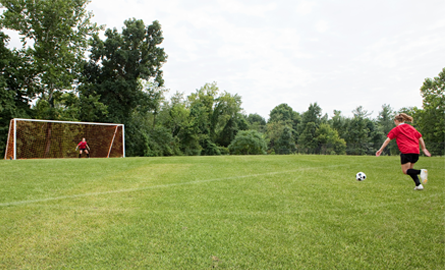 Kids playing soccer in a sports field