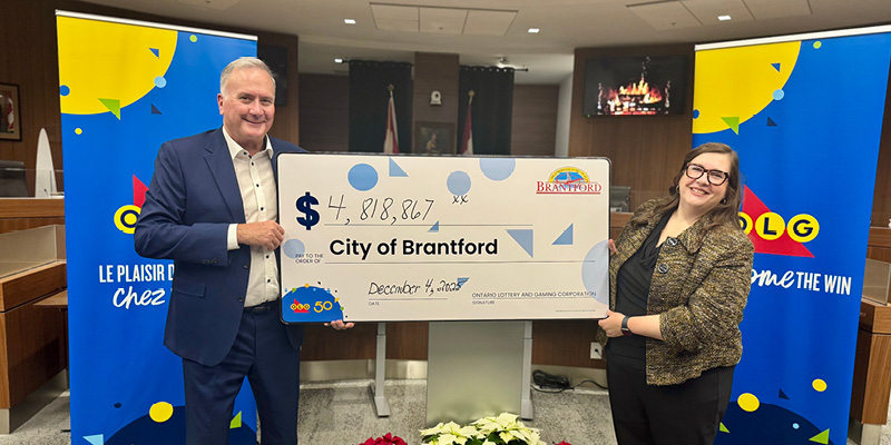 Mayor Davis and OLG representative holding a big cheque at City Hall.
